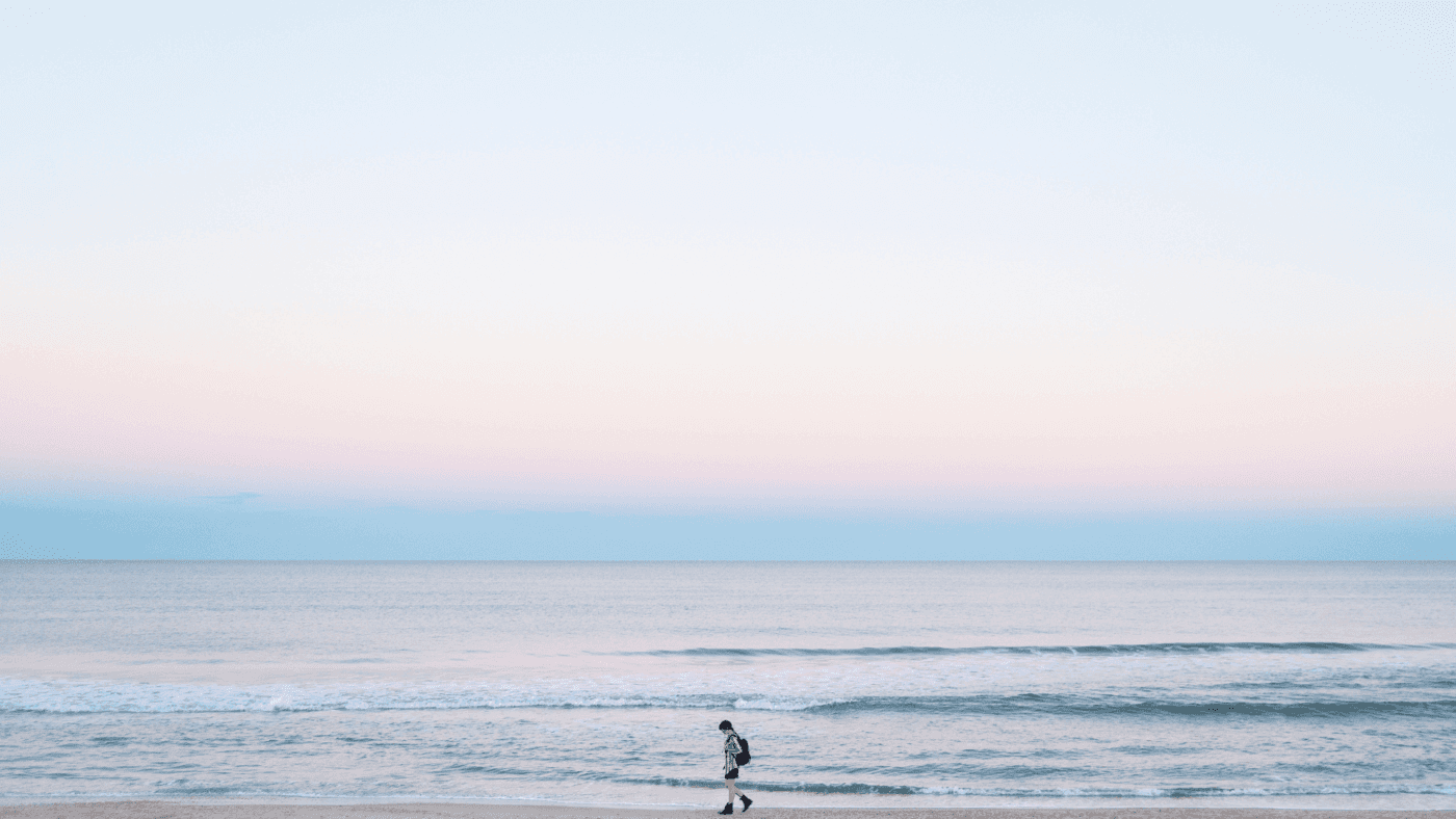 person walking along the beach