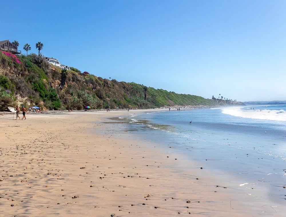 People-walking-along-Swamis-Beach