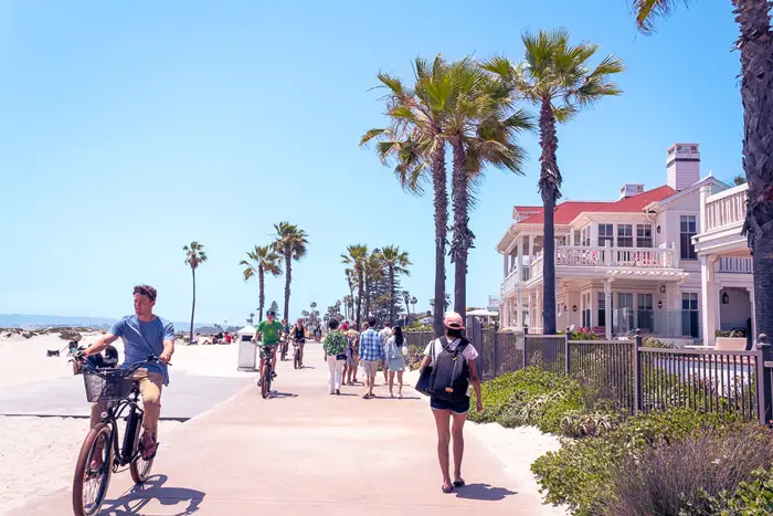 Jess walking along sidewalk of Coronado Beach how to pack for tropical vacation